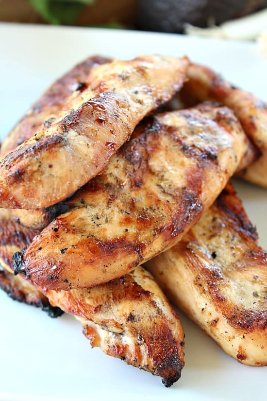 Grilled chicken strips sitting on a white plate.