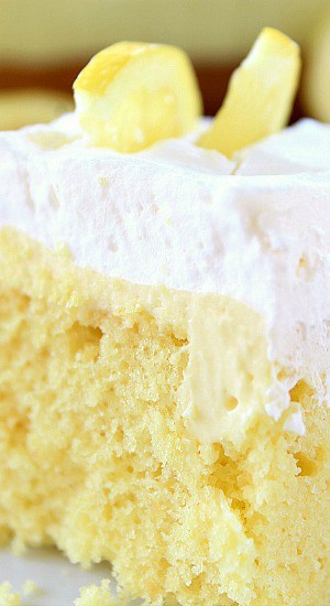 A close up of a piece of cream cheese lemonade poke cake.