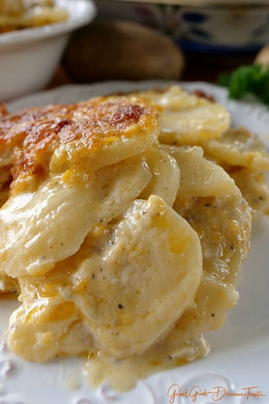A serving of Cheesy Garlic Scalloped Potatoes on a white plate.