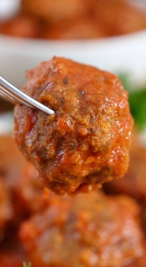 A close up of a homemade meatball on a fork.