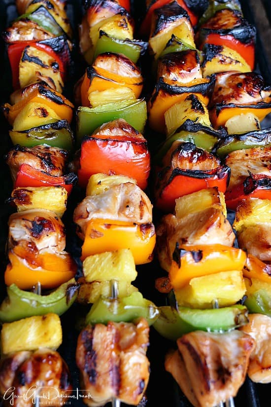 Four chicken kabobs on the grill.