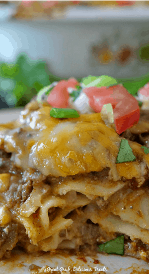 Cheesy Taco Lasagna is made with taco meat, refried beans, and all the ingredients for tacos then layered between lasagna noodles.