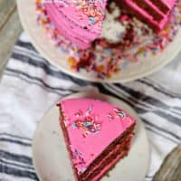 Chocolate Triple Layer Cake is 3 deliciously moist layers of cake, topped with pink buttercream frosting and candied sprinkles.