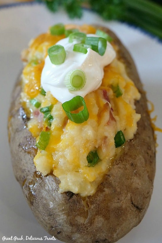 Loaded Twice Baked Potatoes are baked then filled with mashed potatoes, cheese, bacon, sour cream and onions.