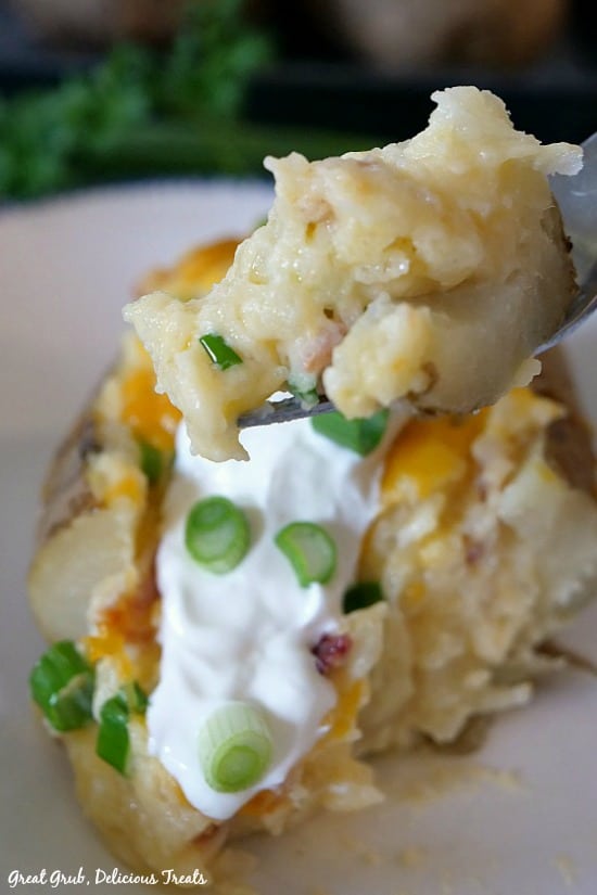 Loaded Twice Baked Potatoes are baked then baked twice with mashed potatoes, cheese, bacon, sour cream, onions and more.