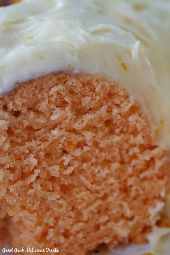 A side view of a slice of Orange Bundt Cake with cream cheese frosting.