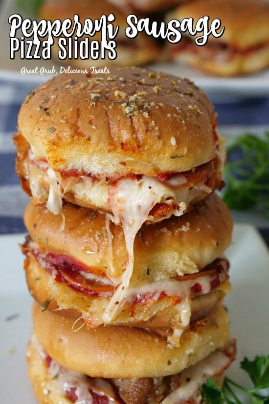 Pepperoni Sausage Pizza Sliders stacked with cheese, pepperoni and sausage, topped with a buttery topping.