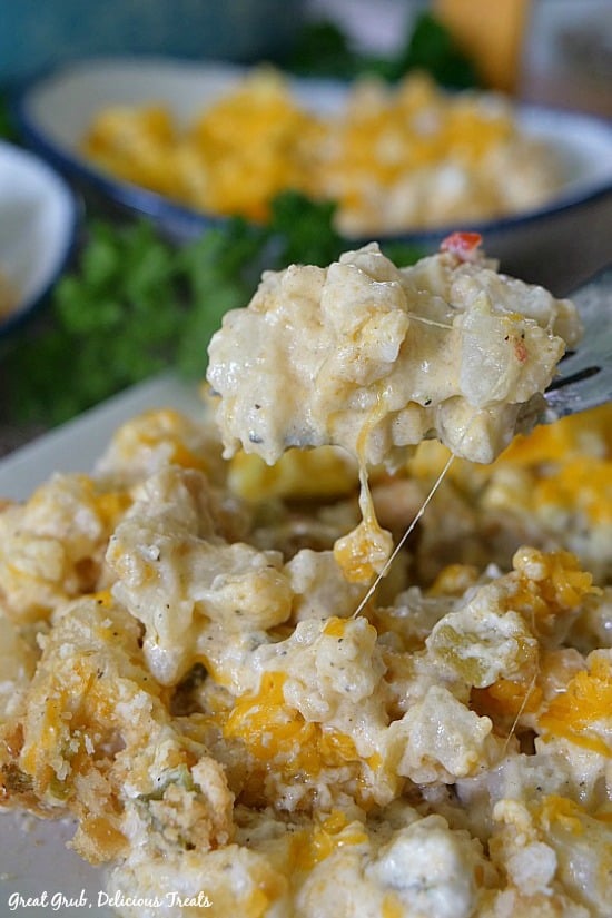 Cheesy Breakfast Potato Casserole is a picture of a scoop of potatoes on a fork.
