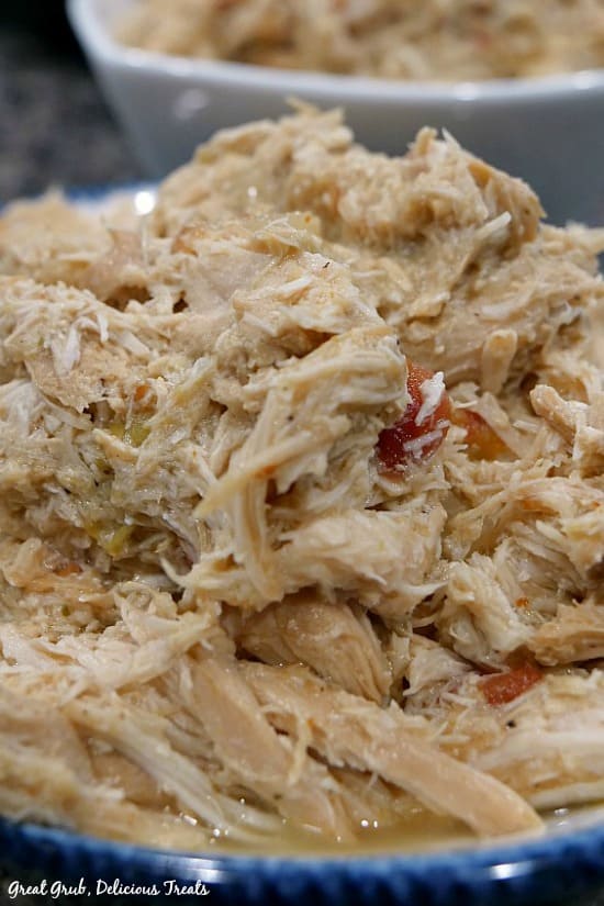 Crock Pot Spicy Chicken- shredded chicken in a white bowl and a bowl with blue trim.