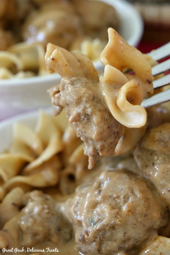 Swedish Meatballs - a fork with half of a meatball with gravy and egg noodles.