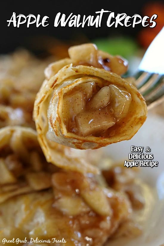 Apple Walnut Crepes - a bite of the crepe showing the apple filling on a fork above a plate of crepes.