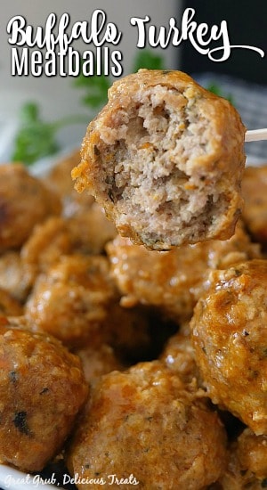 A white bowl of buffalo turkey meatballs with one meatball on a toothpick with a bite taken out of it.