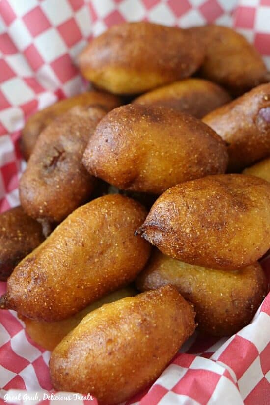 Little smokie corn dogs in a red and white checkered basket.