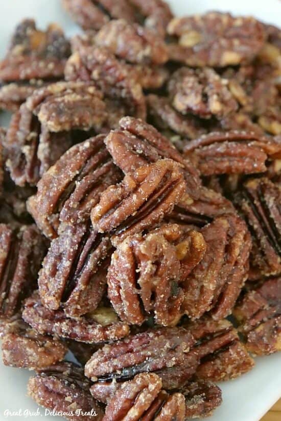 Close up photo of maple candied pecans on a white plate.
