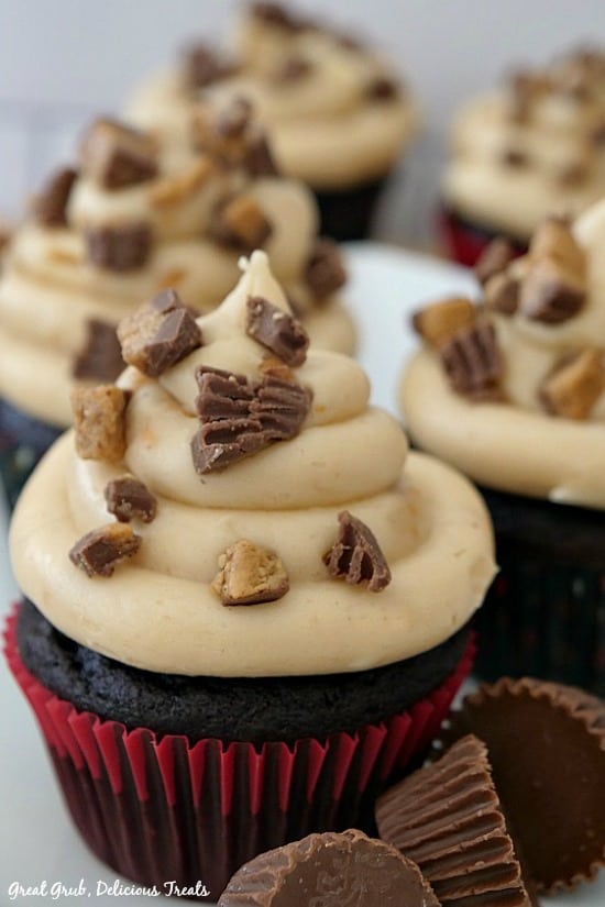 A close up of a chocolate cupcake with peanut butter frosting with 4 more in the background.
