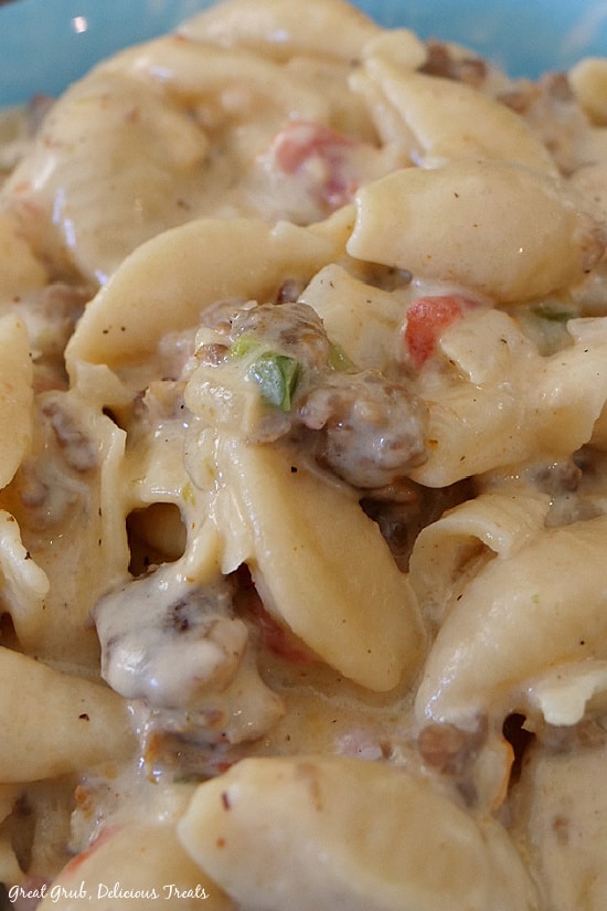 An extremely close up view of Cream Italian Sausage Pasta showing the creamy sauce with pasta shells and Italian sausage.