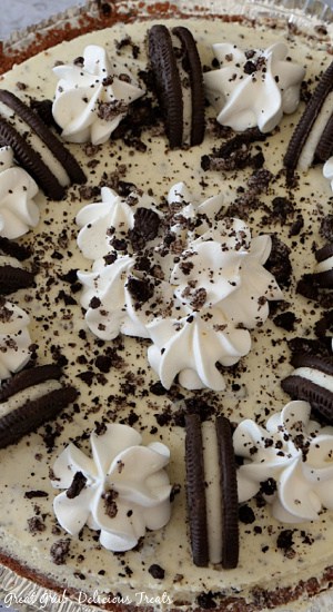 a close up photo of no bake Oreo pie. There are Oreo crumbles, cool whip, and Oreo halves on top of the pie.