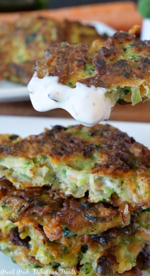 A vegetable patty held up to the camera after it has been dipped in ranch dressing.