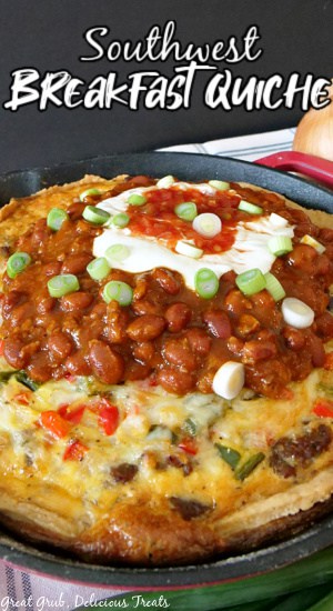 A cast iron skillet with southwest breakfast quiche baked in it, topped with chili, sour cream, and picante sauce.