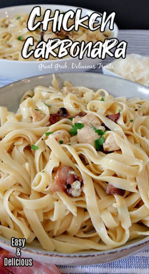 Chicken Carbonara is a simple creamy pasta recipe that is tossed with bacon and chicken. A large white bowl filled with chicken carbonara and sprinkled with parsley and another bowl of pasta in the background.