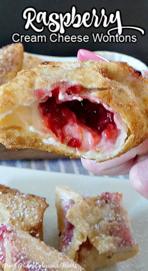 A super close up photo of a half bitten raspberry cream cheese wonton showing the center filled with the raspberry and cream cheese filling.