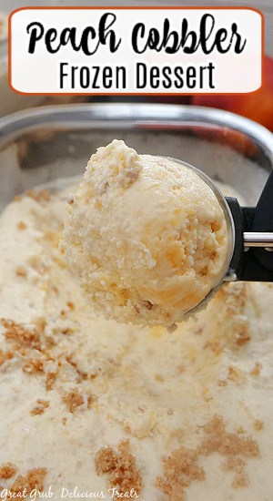 An ice cream scoop full of peach cobbler frozen dessert.