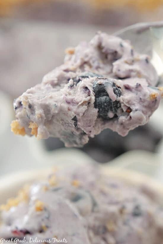 A close up photo of a spoonful of blueberry cobbler frozen dessert.