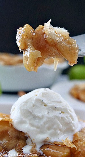 A close up photo of a bite of apple pie on a fork.