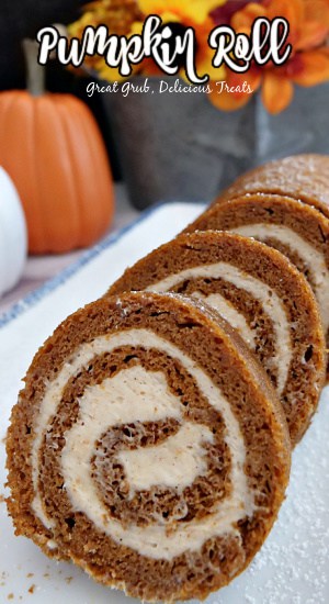 A white plate with a pumpkin roll cake that has been sliced on it.