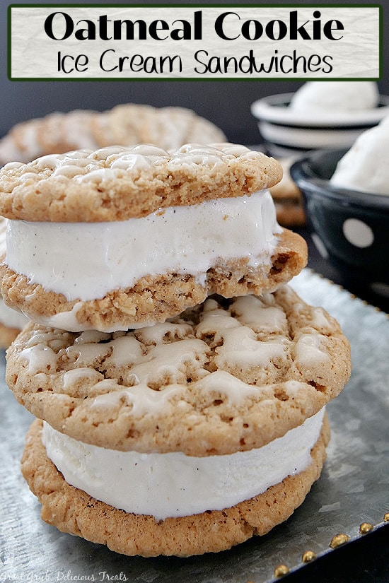 Two ice cream sandwiches stacked on top of each other on a silver plate with 2 bowls of ice cream in the background.