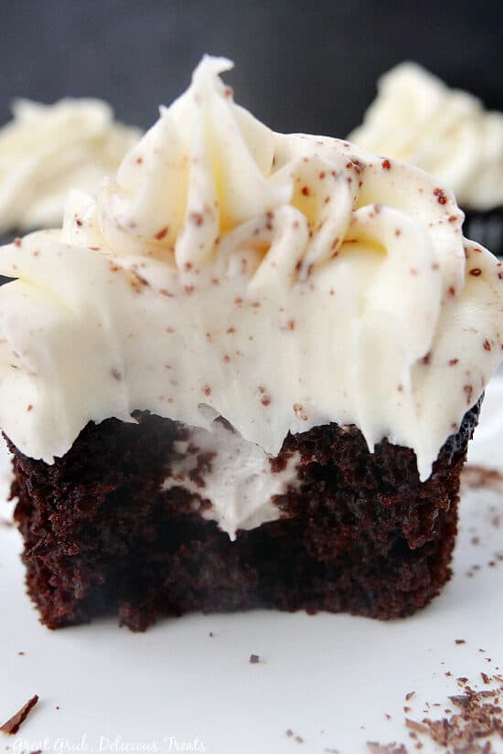 A close up photo of a chocolate cupcake with a bite taken out showing the Oreo pudding filling.