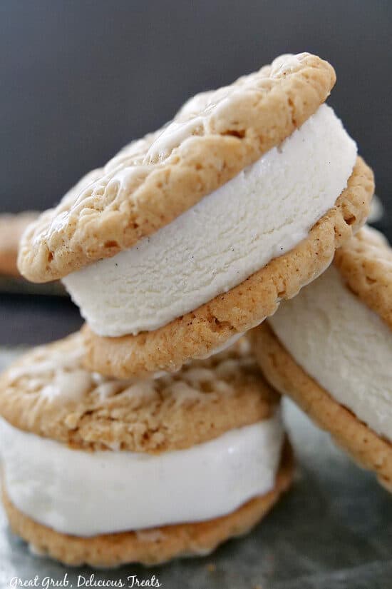 Three oatmeal cookie ice cream sandwiches on a silver tray.