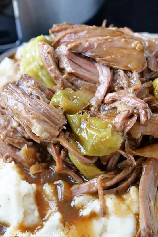 A super close up photo of tender Mississippi Pot Roast that is served over mashed potatoes.