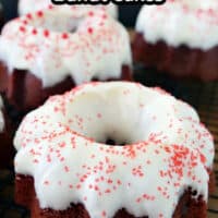 A close up of a mini red velvet bundt cake with cream cheese frosting and sprinkles on it.
