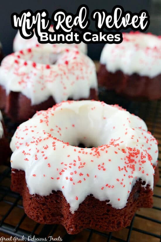A close up photo of a mini red velvet bundt cake with cream cheese frosting and candied sprinkles.