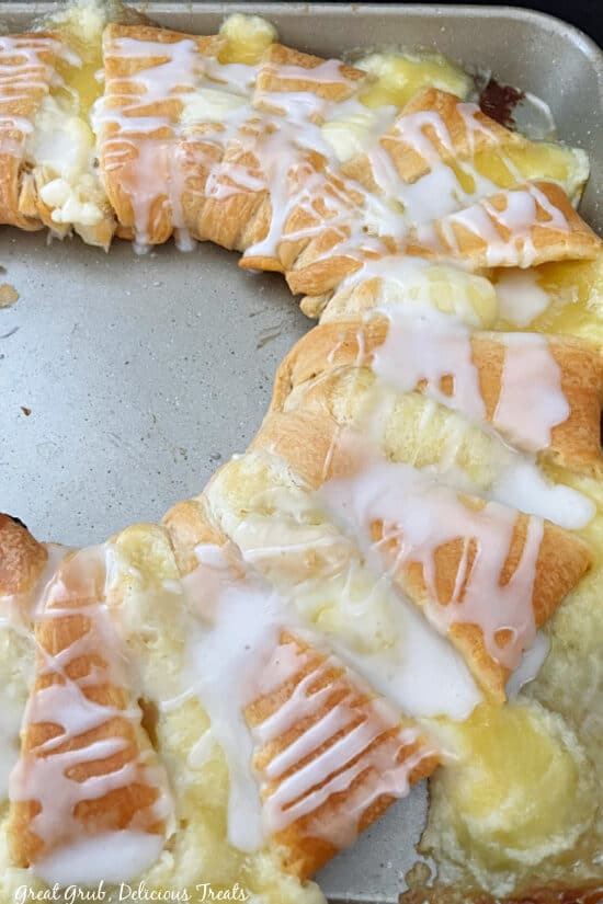 A sliver baking sheet with a lemon pastry ring on it right after being pulled from the oven.