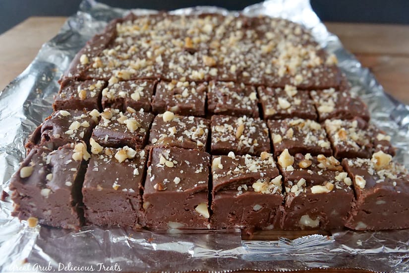 Dark chocolate fudge placed on aluminum foil that has been cut into pieces.