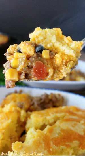 A spoonful of Tamale Pie over a white bowl of Tamale Pie.
