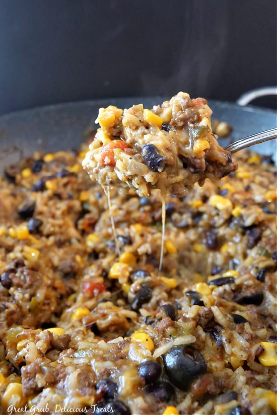 A close up picture of Ground Beef and Rice in the pan with a spoonful taken out.