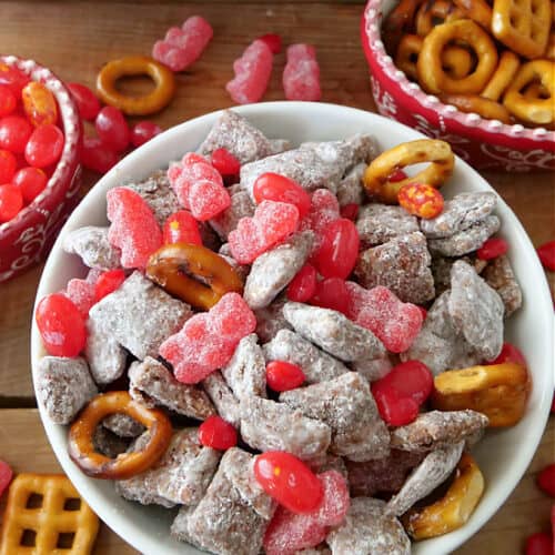 A white bowl filled with Valentine puppy chow snack mix.