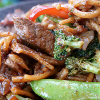A close up photo of beef lo mein.