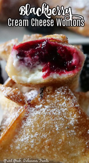 Blackberry wontons stacked on top of one another with a bite taken out showing the blackberry filling and cream cheese.
