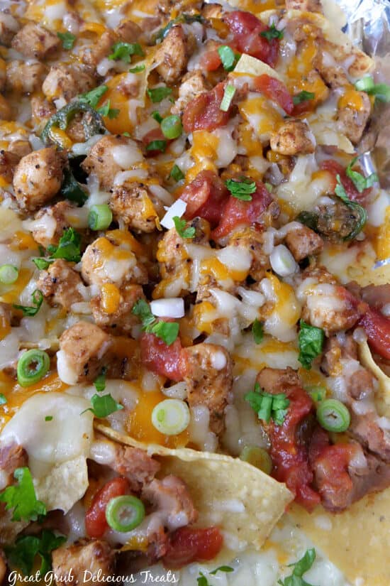 A close up of a baking sheet filled with chicken nachos.