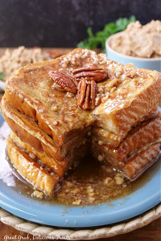 A big stack of French toast covered in syrup and maple pecan butter.