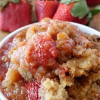 A white bowl filled with strawberry rhubarb crisp.