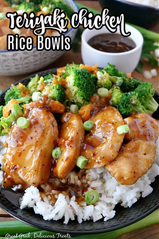 Black bowl filled with white rice, broccoli, carrots, chicken, and drizzled with teriyaki sauce.