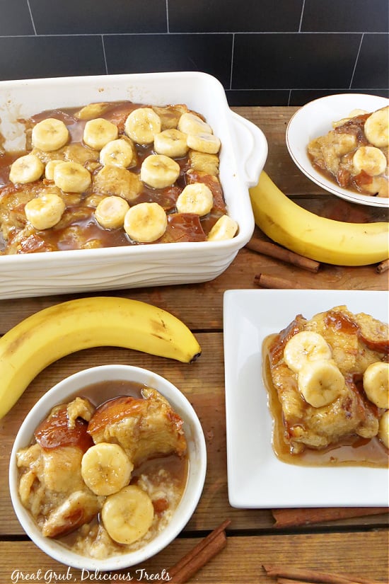 An overhead photo of banana putting in a casserole dish, on white plates, and with bananas on the board for decoration.