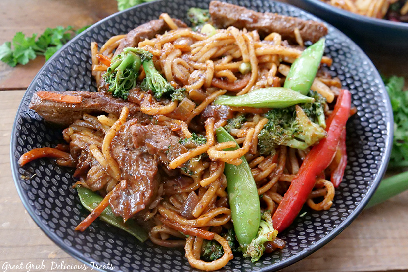 A black bowl with beef lo mein.