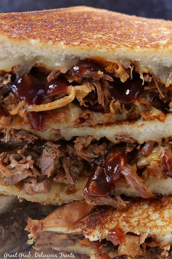 A close-up picture of brisket grilled cheese cut in half.