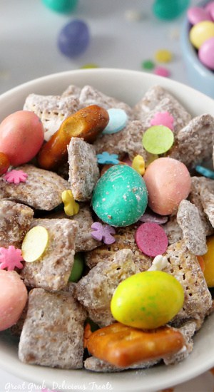 A close up photo of a white bowl filled with Easter Muddy Buddies.